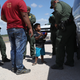 A boy and father from Honduras are taken into custody by U.S. Border Patrol agents near the U.S.-Mexico Border on June 12, 2018, near Mission, Texas.